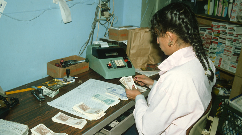 A supermarket clerk counts used food stamps