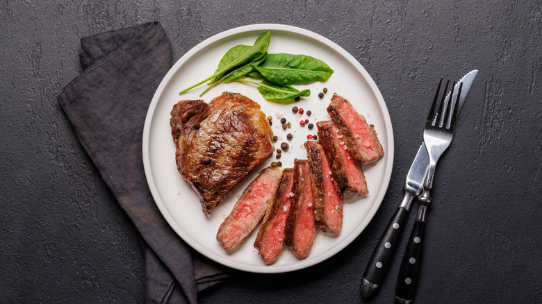 A medium-rare steak on a restaurant plate