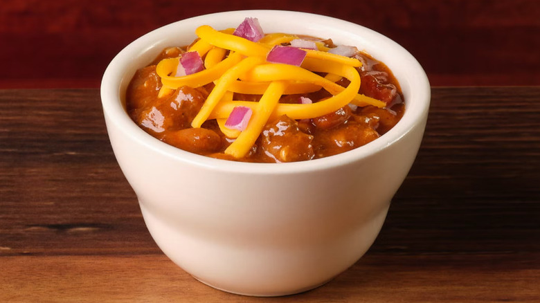 Close up image of Texas Roadhouse chili topped with cheese and onion
