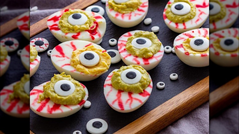 Deviled eggs with red veins and candy eyeballs on top