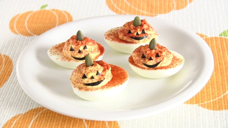 Plate of deviled eggs made to look like they have jack-o'-lantern filling