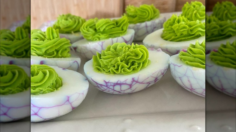 Purple spiderweb deviled eggs with green filling