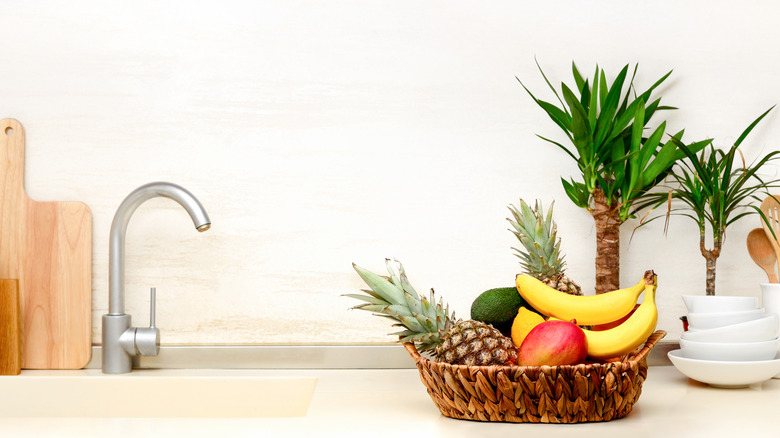 Fruit in a woven basket in a clean, minimalist kitchen