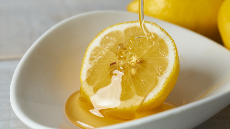 Honey is poured on a lemon