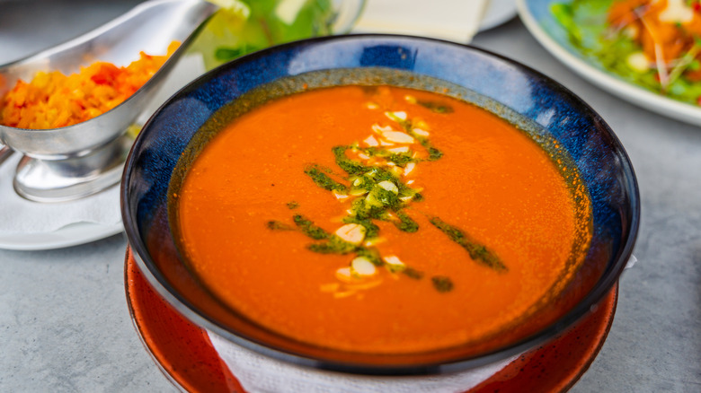 Tomato soup with pesto and cheese on top