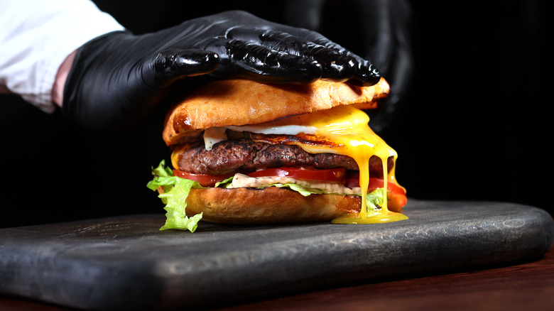 chef stacking juicy burger