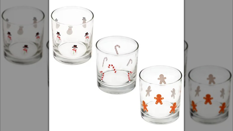 Clear rocks glasses, each with either snowmen, gingerbread men, or candy canes printed on the outside
