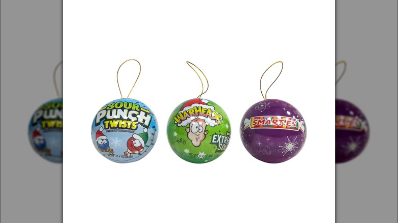 Three small assorted ball ornaments with candy brands printed on them
