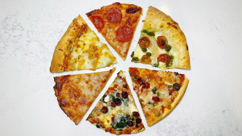 Six slices of different pizzas arranged in a circle