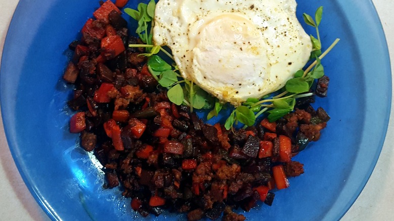 Bowl of red flannel hash with a fried egg