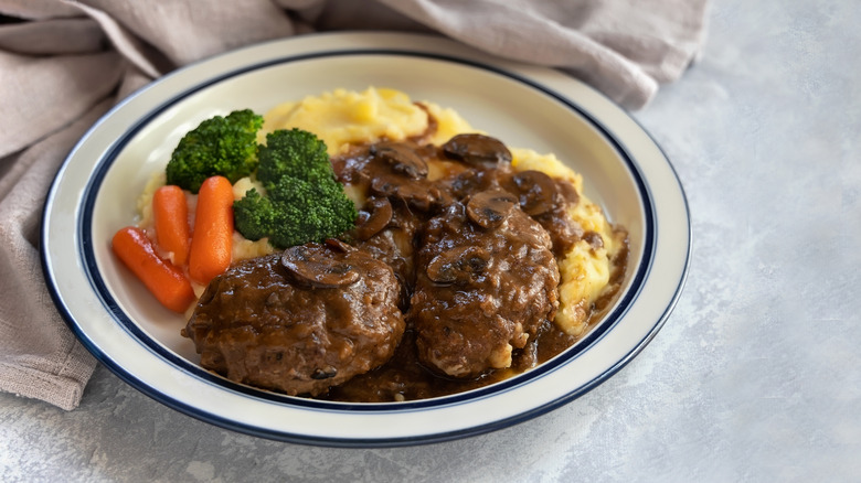 Salisbury steak with broccoli, carrots, and mashed potatoes