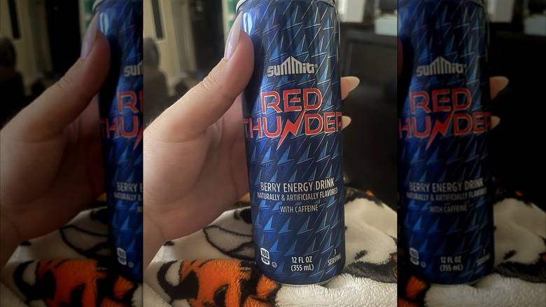 Hand holding can of Red Thunder