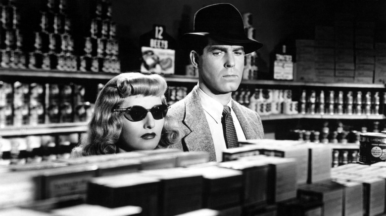 a black and white still of Barbara Stanwyck and Fred MacMurray in a grocery store