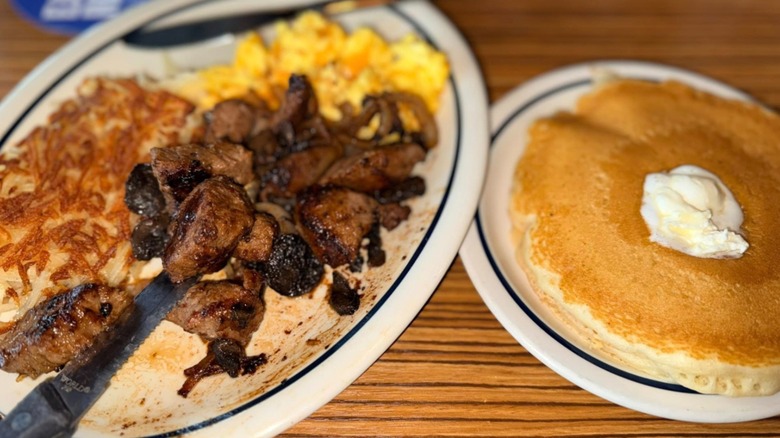 A breakfast combo meal at IHOP with steak, eggs, hashbrowns, and pancakes