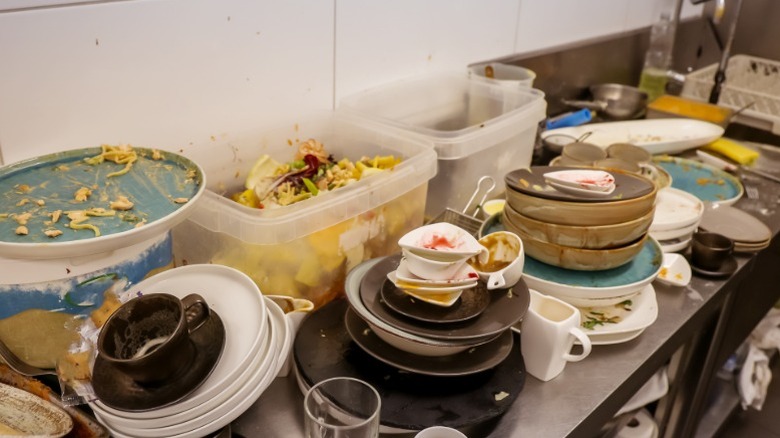 industrial kitchen with stacks of dirty dishes