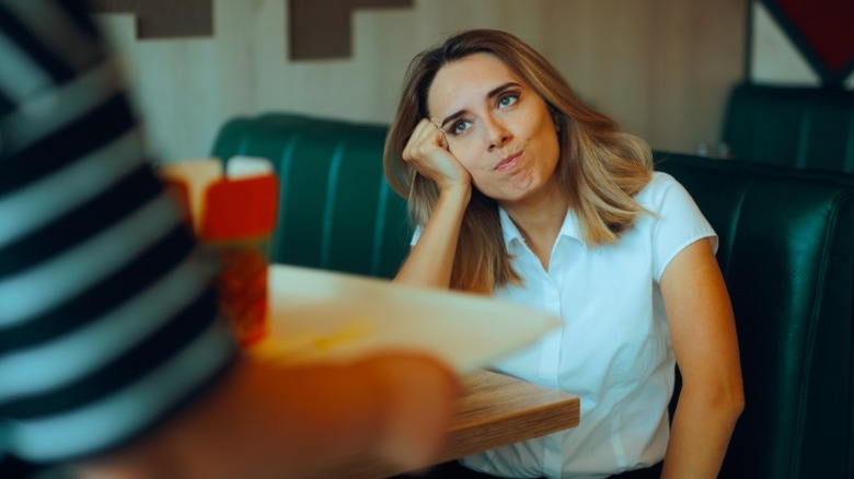 woman looking bored waiting at restaurant
