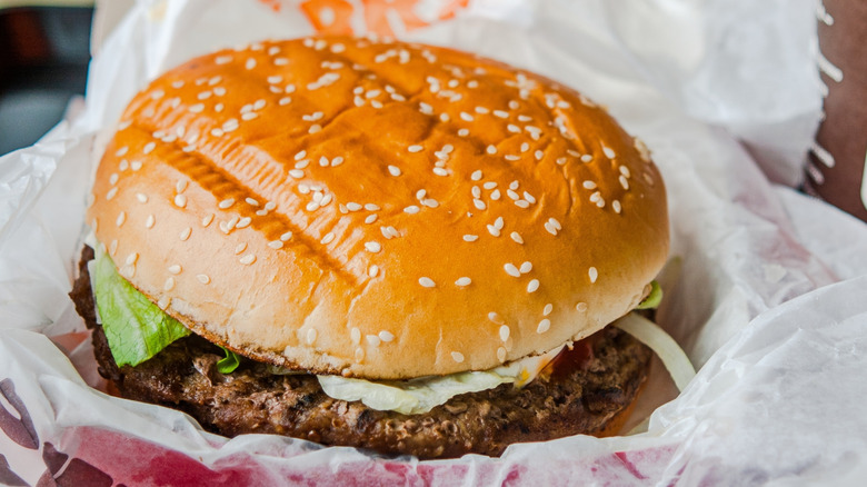 A Whopper is displayed on a Burger King wrapper