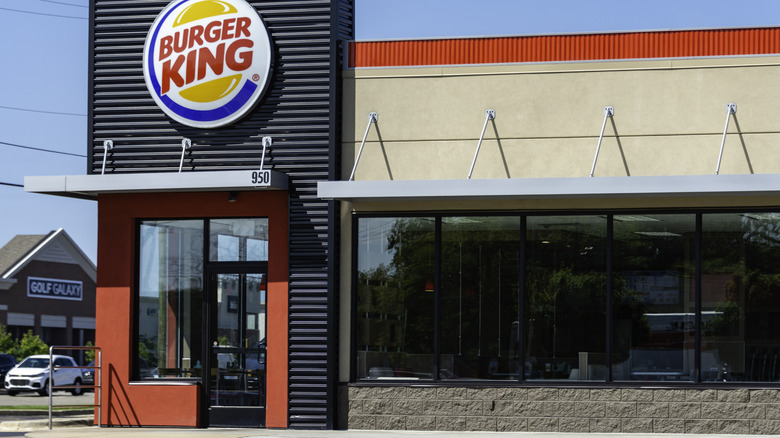 The exterior of a Burger King restaurant is seen against a blue sky