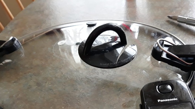 A broken Crockpot lid on a kitchen table