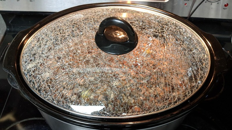 A Crockpot slow cooker with shattered lid on a stovetop