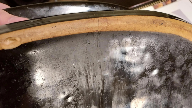 A close-up of a Crockpot ceramic pot with crack in it