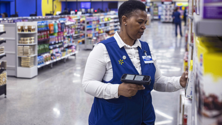 Walmart associate picking up merchandise from shelf