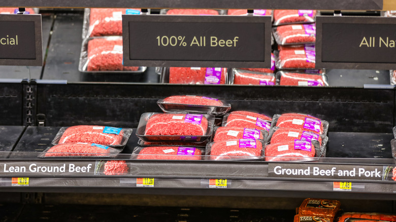 Packaged ground beef in Walmart, price tags on shelves visible
