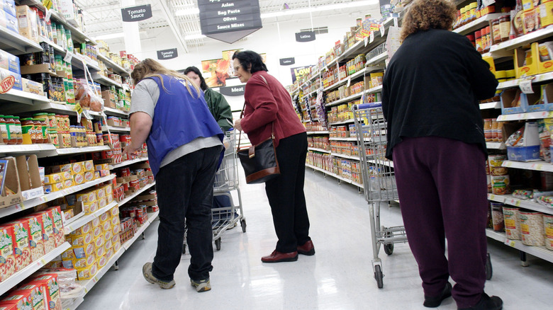 Shoppers and associates crowding narrow Walmart aisle