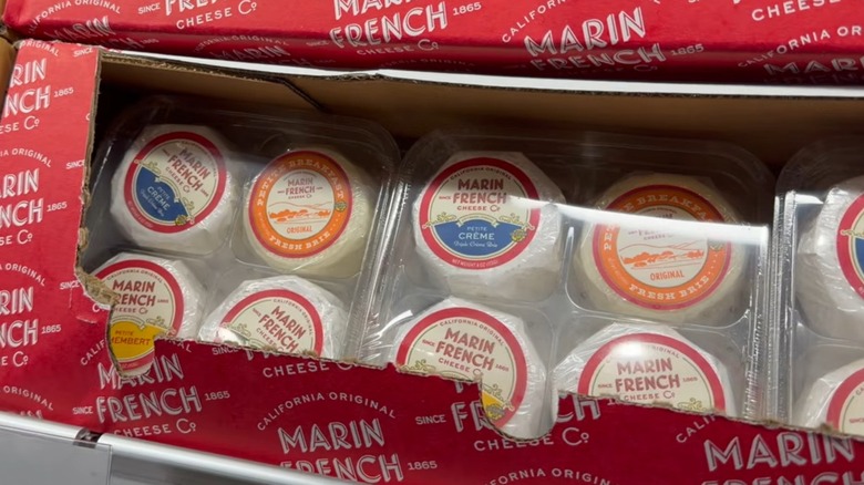 Clear plastic containers with four 4-oz wrapped wheels of brie and camembert cheeses