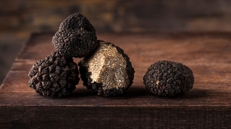 Black truffles on a wooden board