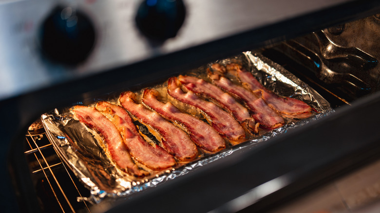 Bacon strips on a baking tray inside an oven