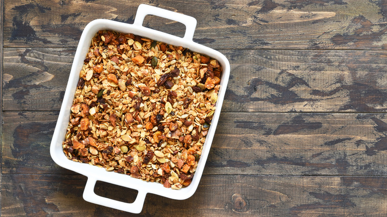 A baking dish full of granola on a wooden table
