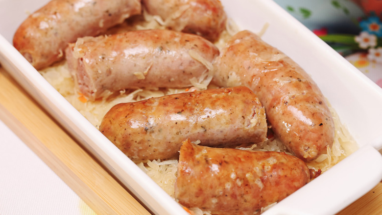 Baked sausages over sauerkraut in a baking dish