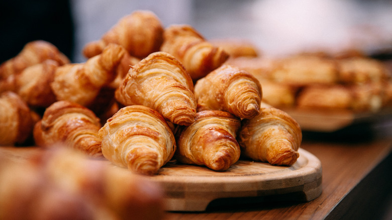 A stack of fresh croissants on bakery counter