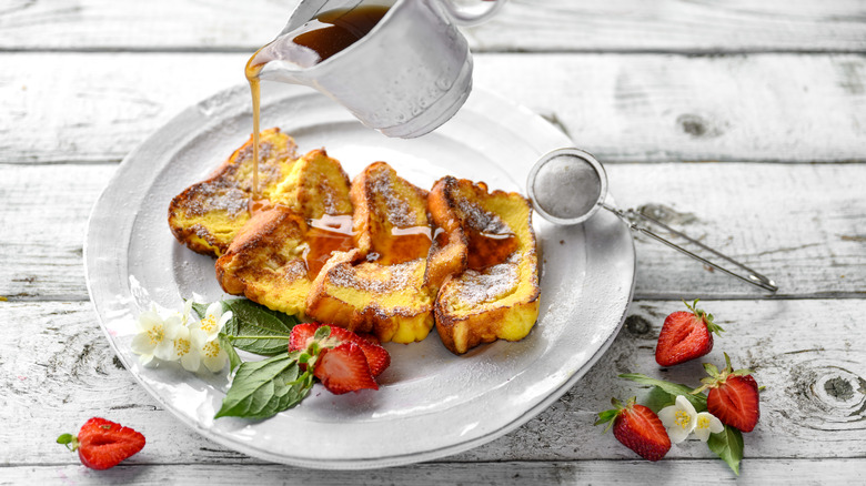 Syrup being poured onto slices of French toast