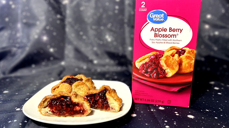 One whole and one sliced Great Value apple blossom on plate next to package