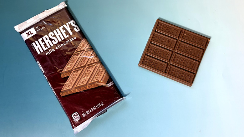 Piece of Hershey's milk chocolate bar next to packaged bar