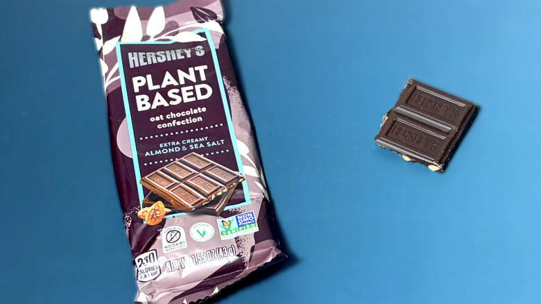 Piece of Hershey's plant based chocolate bar in next to packaged bar