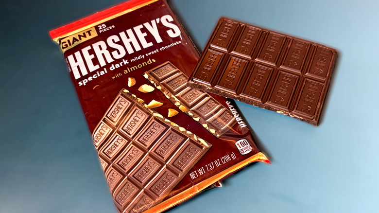 Piece of Hershey's dark chocolate almond bar in front of packaged bar