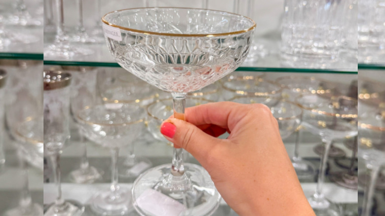 Hand holding glass stemware in HomeGoods