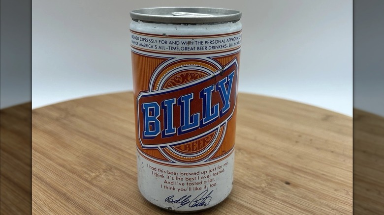 A can of Billy Beer with a red, blue, and orange logo with white detailing, and Billy Carter's signature