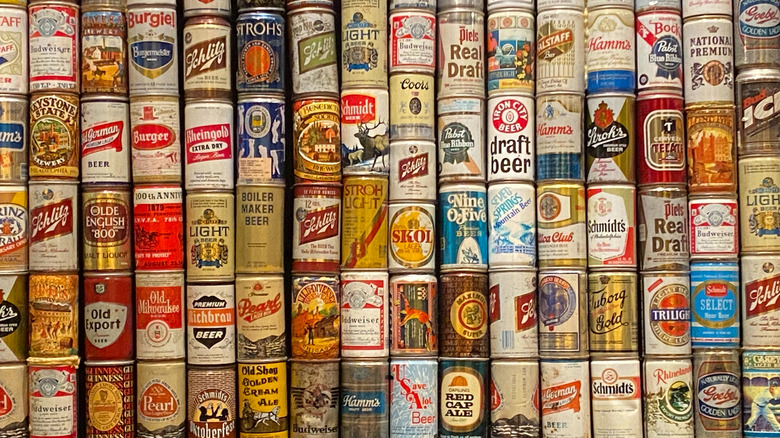 A neatly stacked collection of assorted vintage beer cans