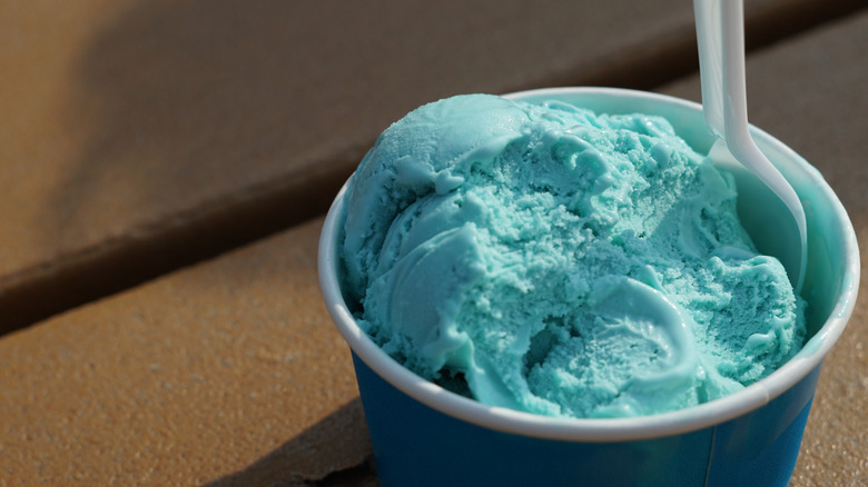 Close-up on a plastic spoon in a to-go cup of blue moon ice cream