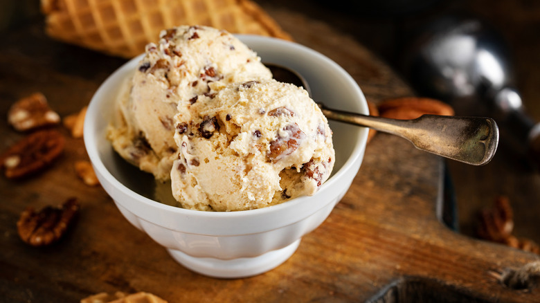 A bowl of butter pecan ice cream on a table