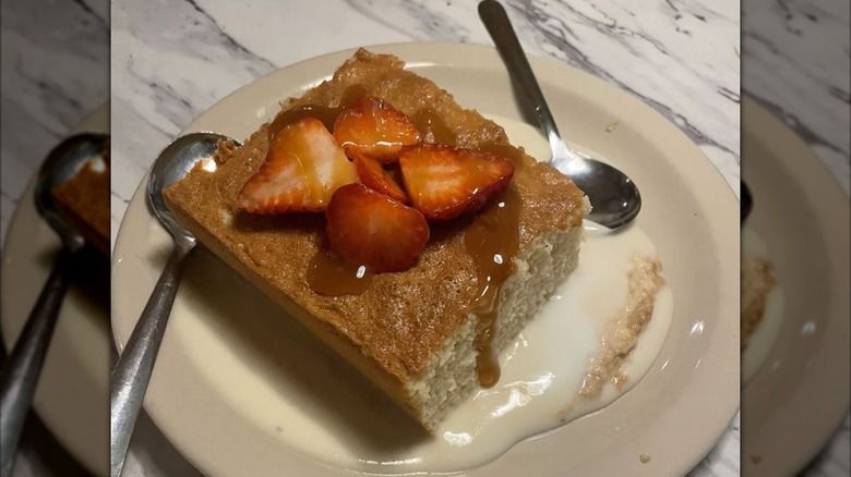 Chuy's Homemade Tres Leches cake on a beige plate with spoons