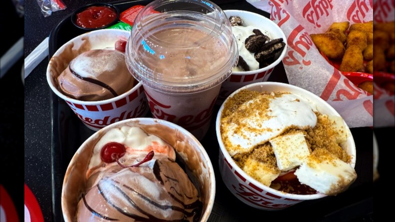 A variety of custard desserts in paper cups from Freddy's Frozen Custard and Steakburgers