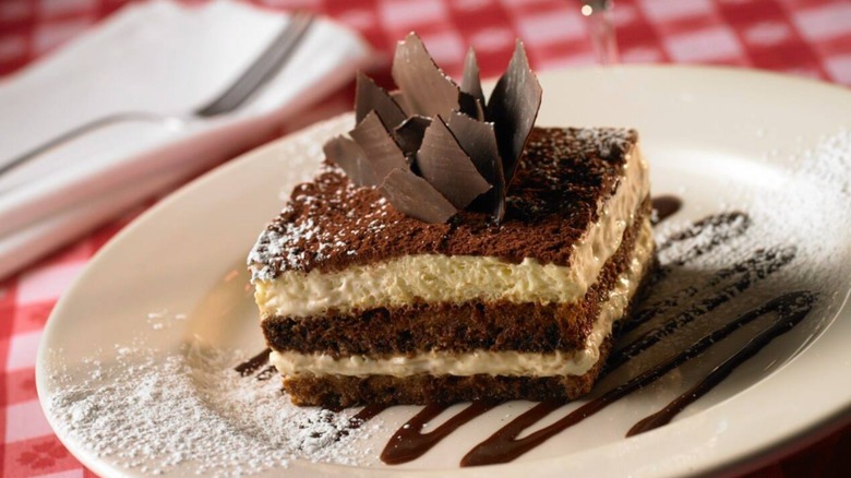 Tiramisu with chunks of chocolate sticking out from Maggiano's on a red tablecloth