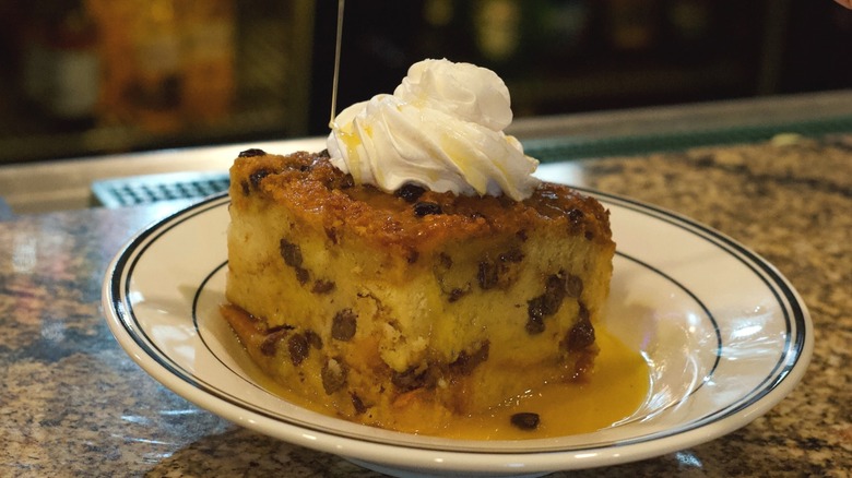 Mimi's Cafe's bread pudding on a white plate with whipped cream on top