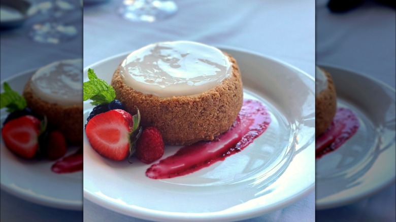 Ruth's Christ Steak House round cheesecake with berries and jam on a white plate