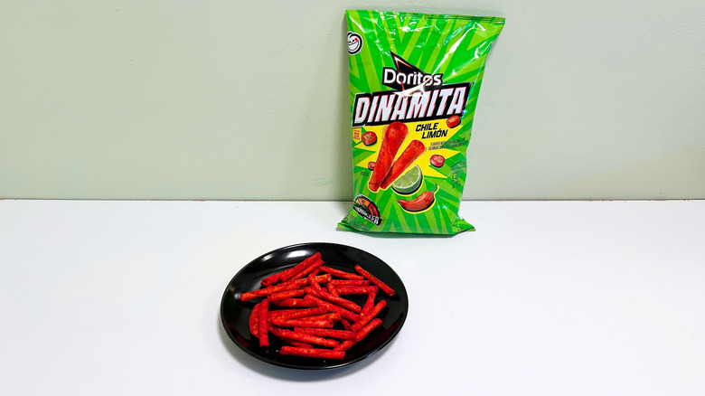A bag of Doritos Dinamita Chile Limon next to a black plate of chips